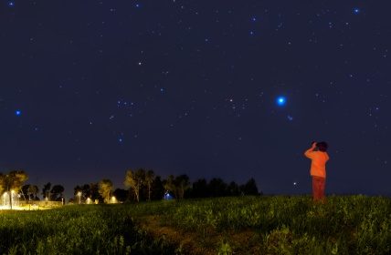 Kid looking at the stars with binoculars