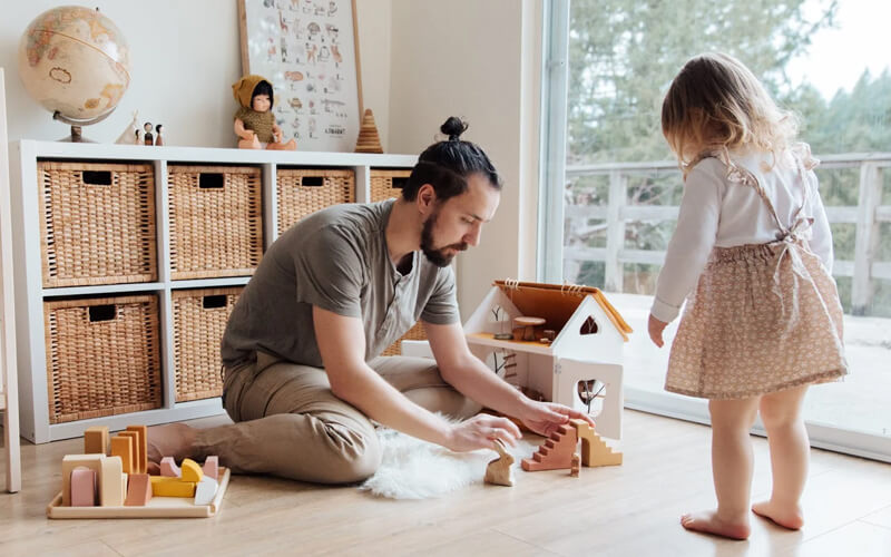 father guiding his kid during play - Parenting Style Influences Your Child’s Popularity